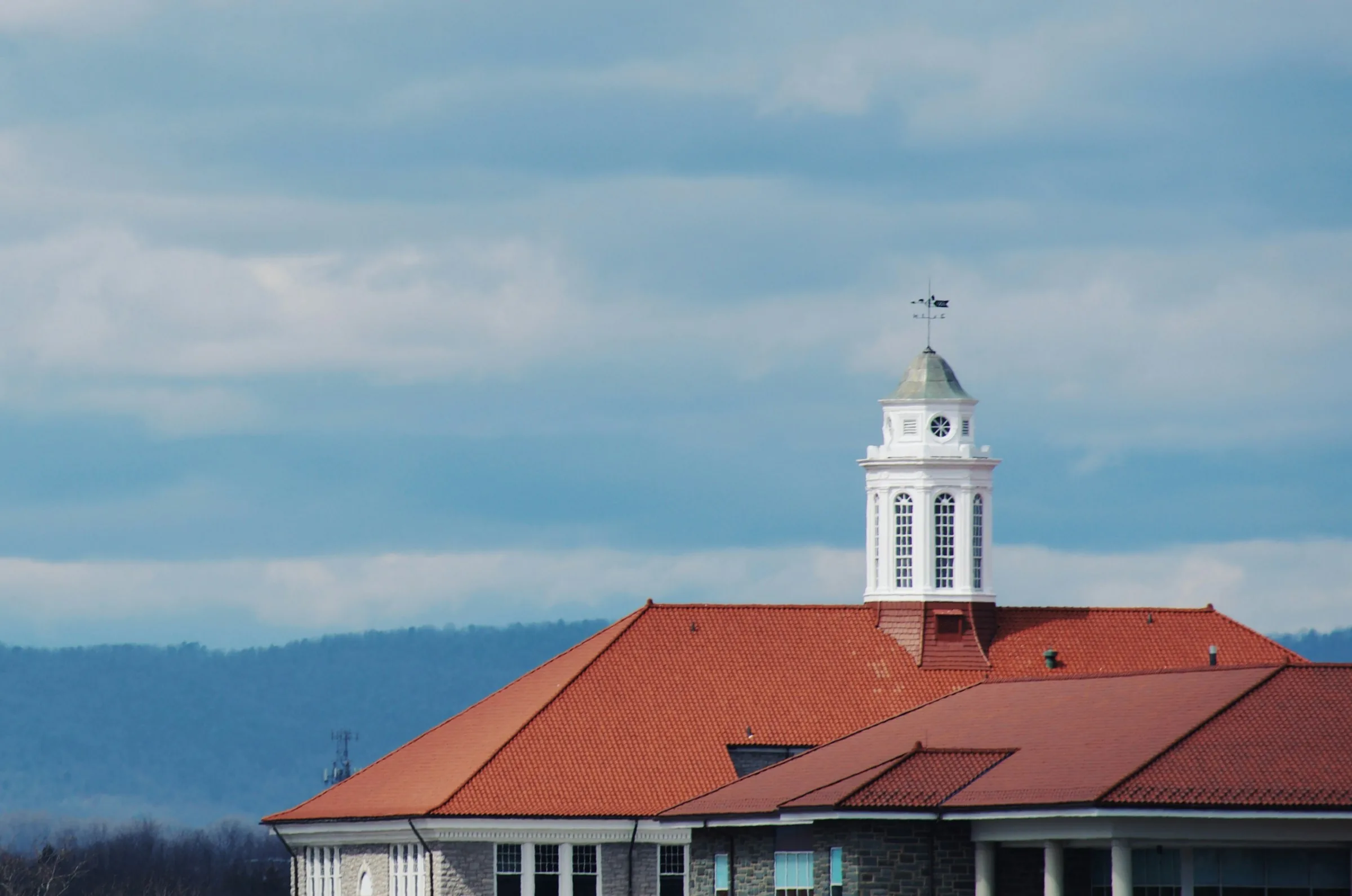Wilson Hall at James Madison University with the Shenandoah Valley mountains behind it